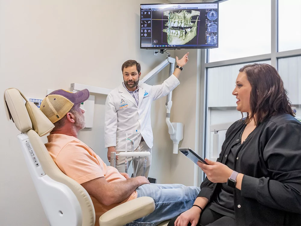 Dr. Benjamin Kacos in Exam Room with patient and assistant